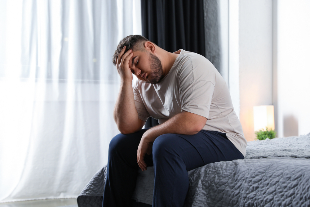 A man with high blood pressure has troubled sleep due to sleep apnea.